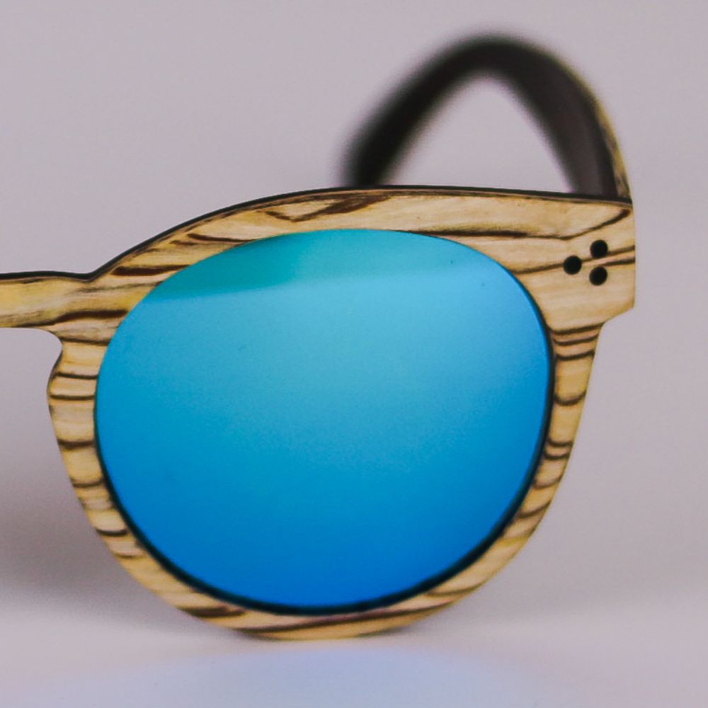 Detalle ampliado del frontal de las Gafas de Sol ERIKA SAVAGE en el que se puede apreciar los embellecedores de los remaches de las bisagras y el color blanco marfil y zebrano de la montura
