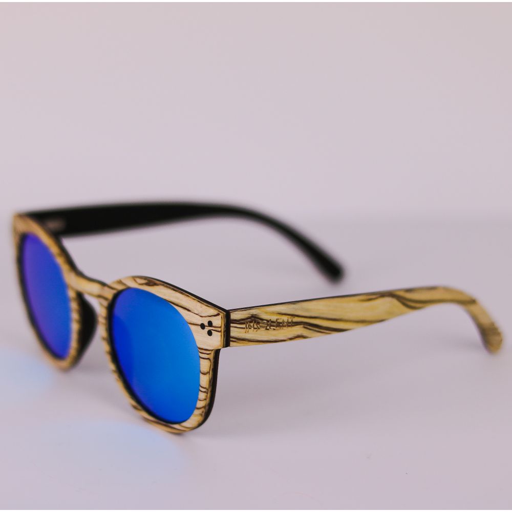 Patillas de las Gafas de Sol ERIKA SAVAGE se aprecia el sistema de fijación de las bisagras con tres remaches, su color blanco marfil zebrano y las lentes celestes